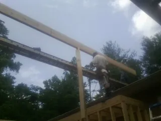 Carpenter setting a ridge beam over a new addition frame — Ice Dam Removal by Roofing Brothers in Barnesville
